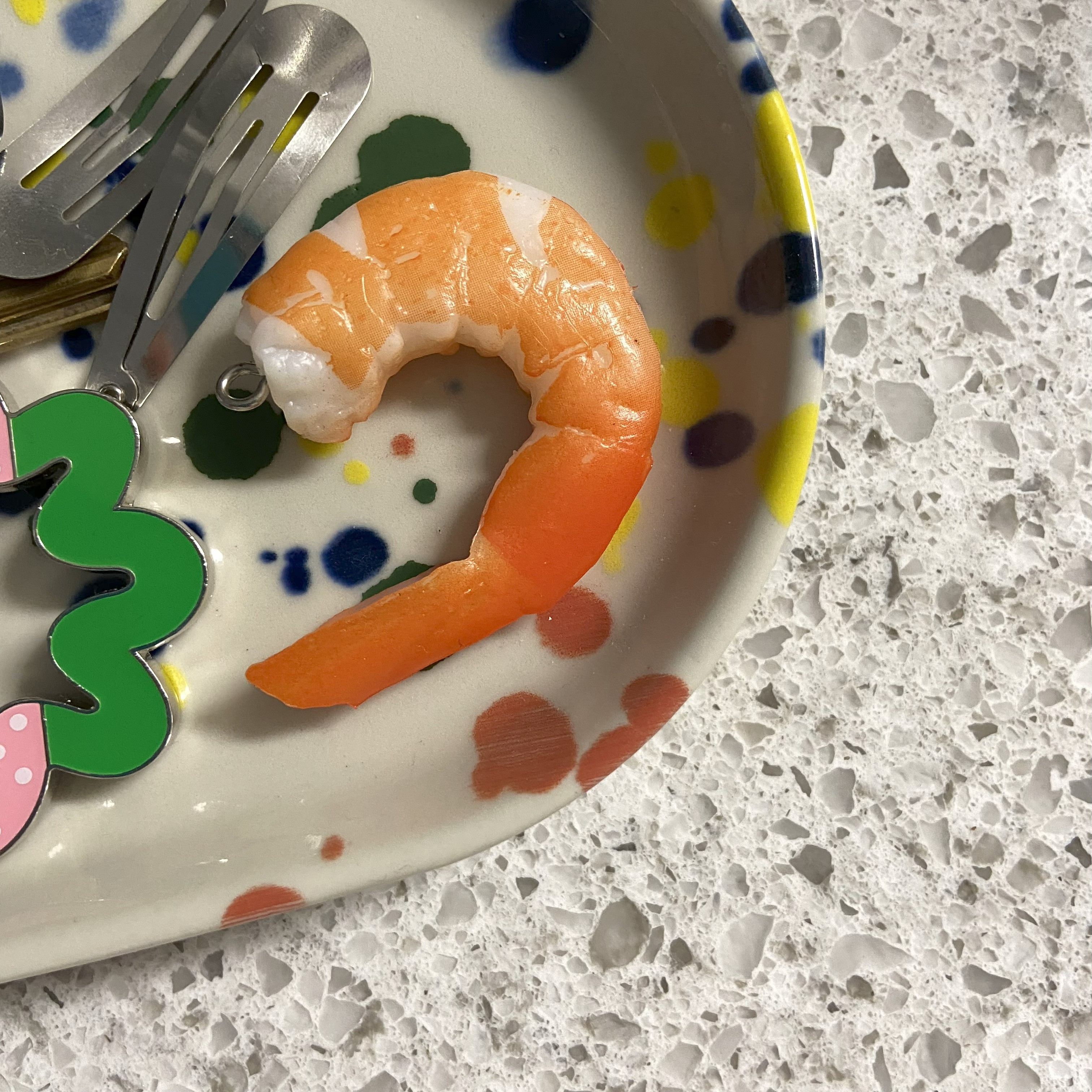 a plastic cooked shrimp keychain in a trinket dish